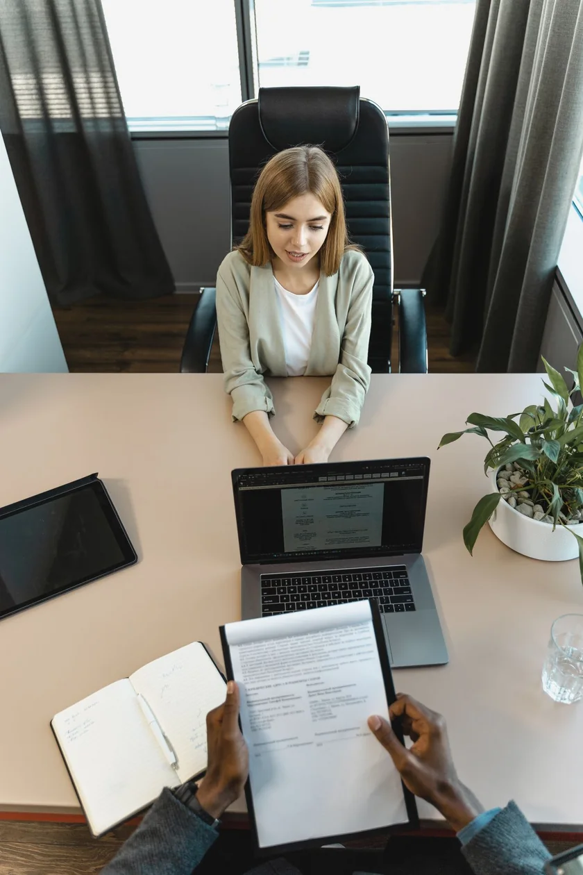 A candidate seated across the desk from an interviewer in a modern office